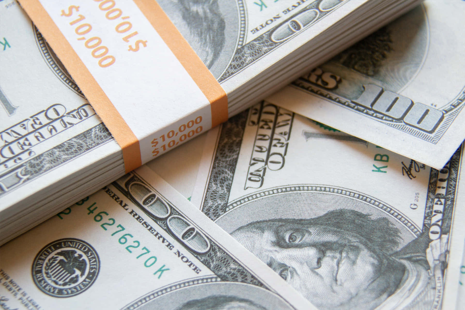 一疊美國一百美元鈔票，帶有橙色標籤寫著$10,000