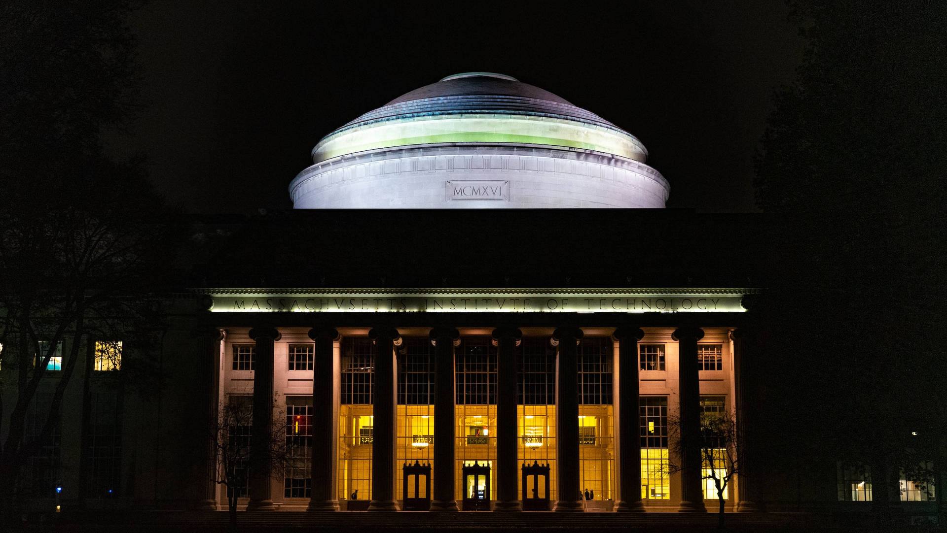 夜晚宏偉的照明大學建築，帶有發光的窗戶和柱子。