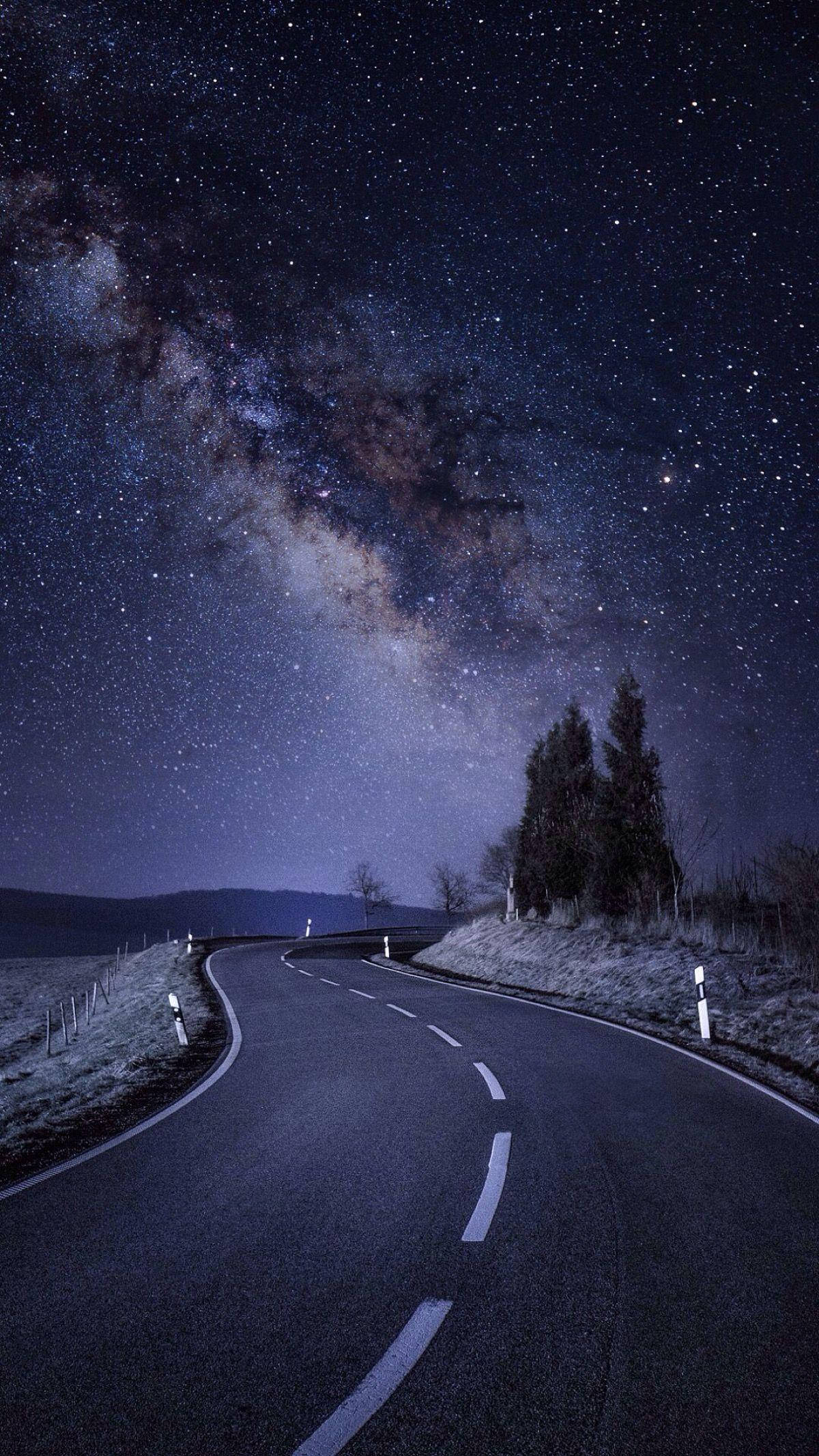 星夜公路 iPhone SE 壁紙 — 一條蜿蜒的道路在壯麗的星空下彎曲，銀河拱掛在上方。