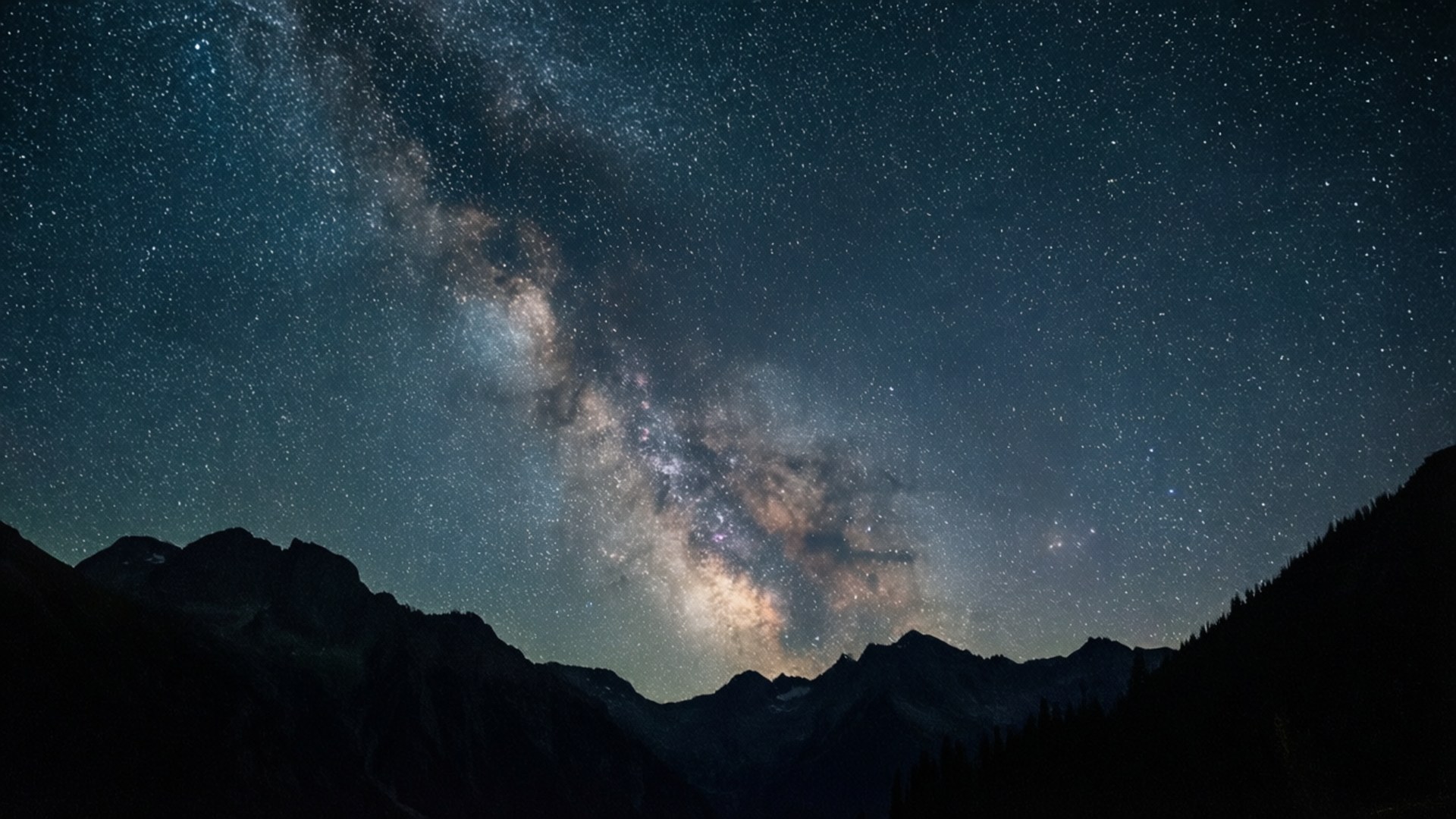 星夜群山 壁紙 — 令人驚嘆的夜空充滿了無數星星，發光的銀河在黑暗的山峰剪影上拱起。