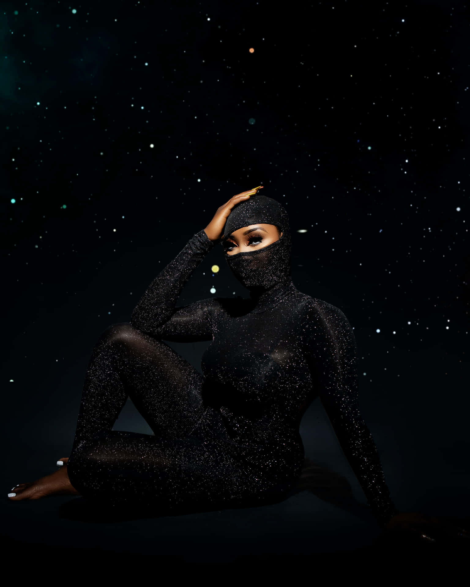 一位身穿閃亮黑色連體衣的女性，在星空夜空背景下擺姿勢。