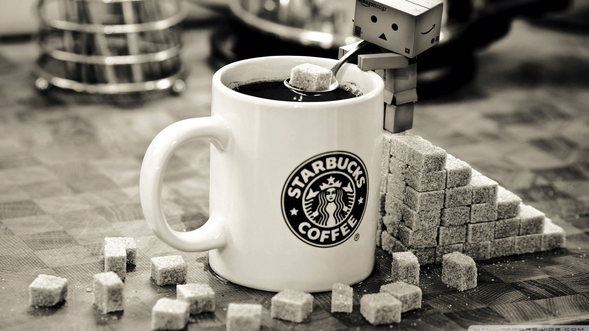 一個機械人正在為被方糖包圍的Starbucks咖啡杯加糖。