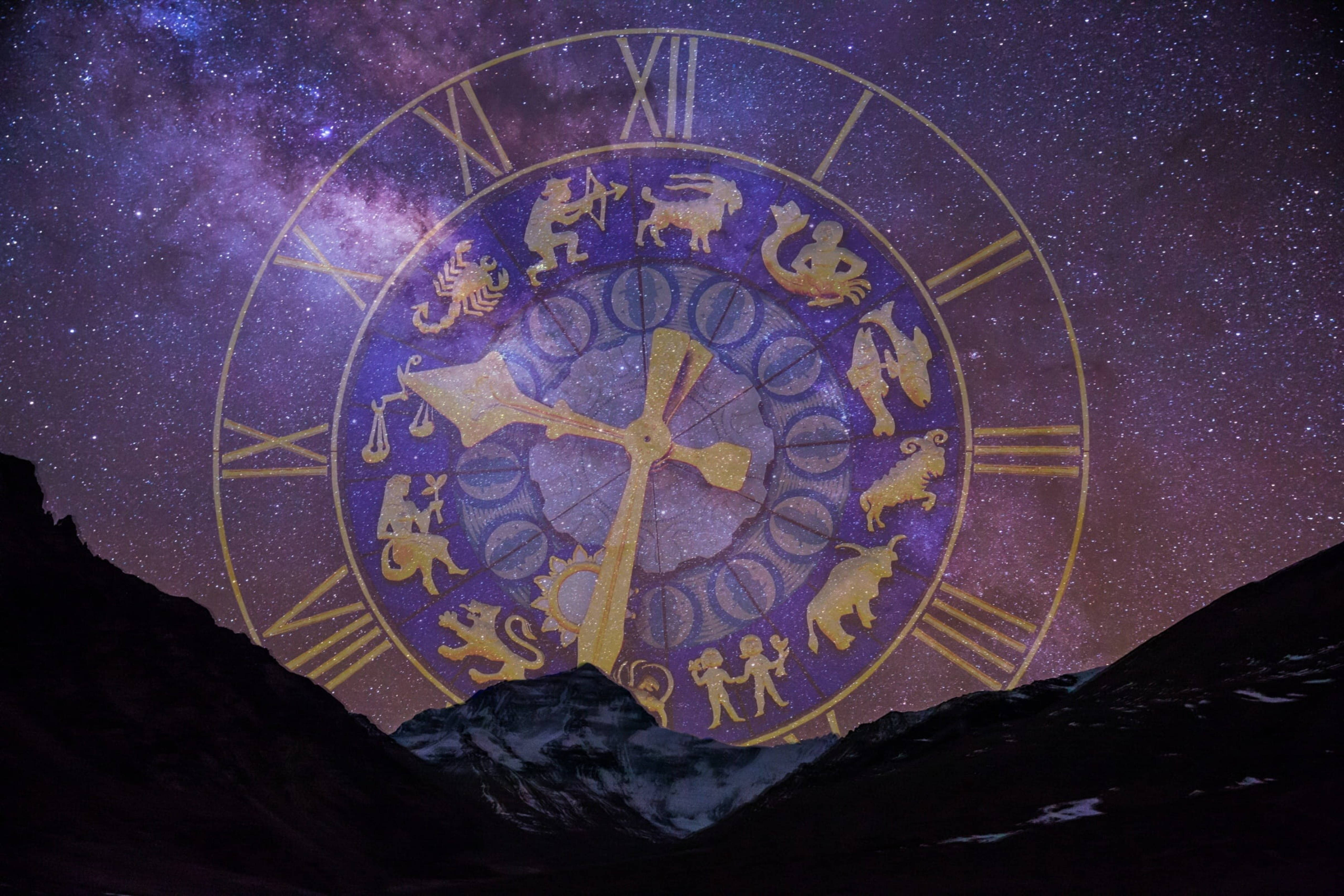 星座夜空鐘錶 壁紙 — 一個金色星座時鐘漂浮在繁星點點的紫色銀河天空中，四周環繞著黑暗的山峰。