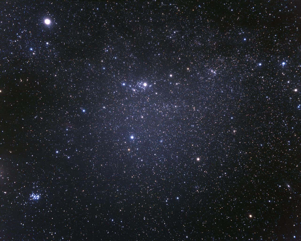 星座的天體交響曲 壁紙 — 在深邃的黑色宇宙背景下，無數閃爍的星星和幾個明亮的天體構成了令人嘆為觀止的密集星場景觀。