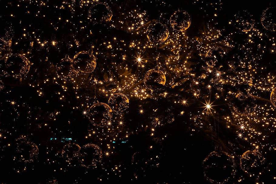 充滿閃爍光芒的金色氣泡懸掛在漆黑的夜晚場景中。