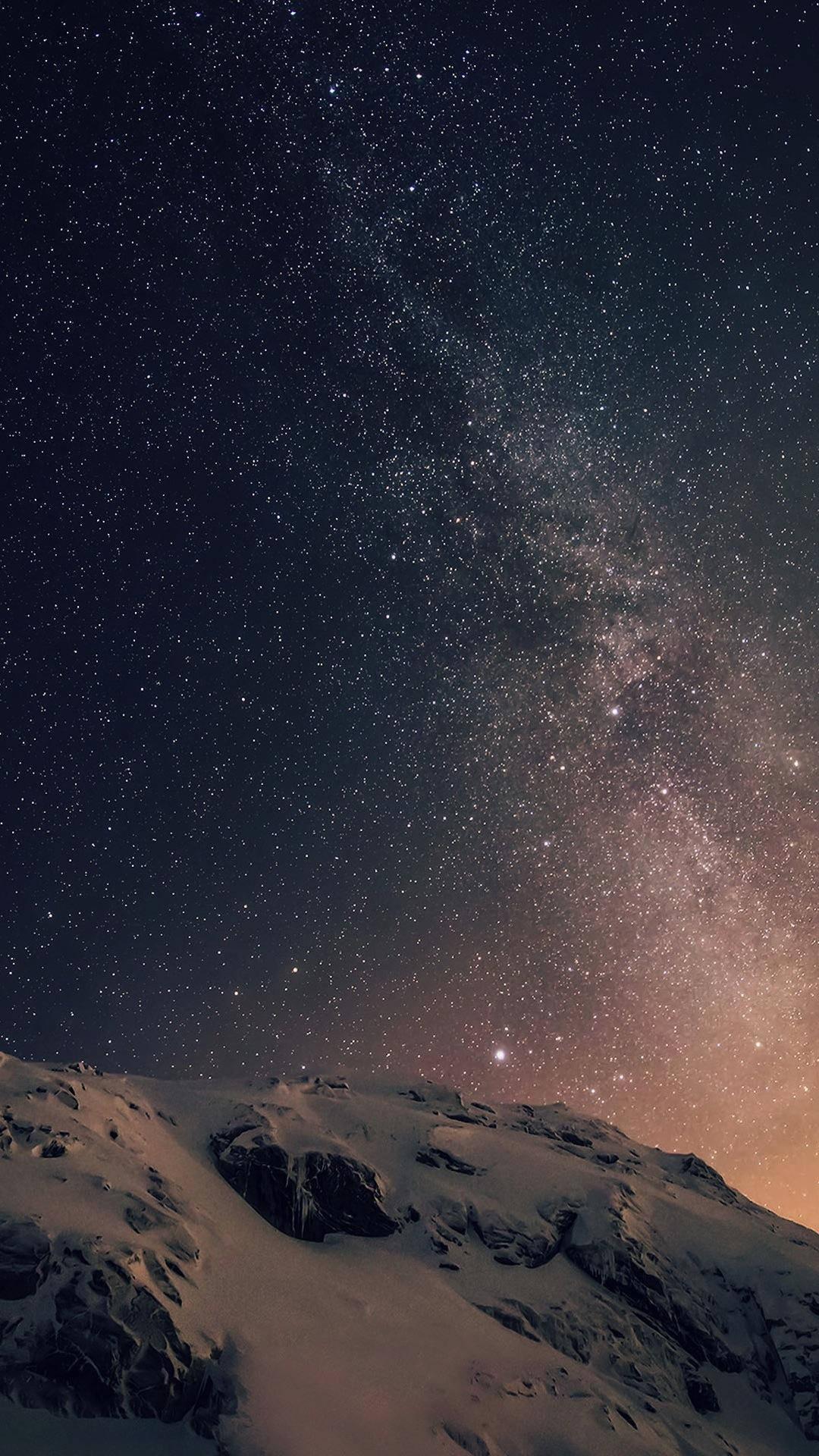 星空下的岩石地形 iPhone 8 生動背景 壁紙 — 白雪覆蓋的山脊，在令人驚嘆的星空下，銀河散發著溫暖的色彩。