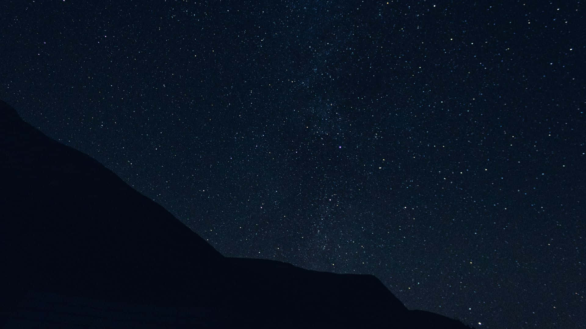 Dark Night 桌布 壁紙 — 星空夜空，銀河在黑暗山脈剪影上拱起。