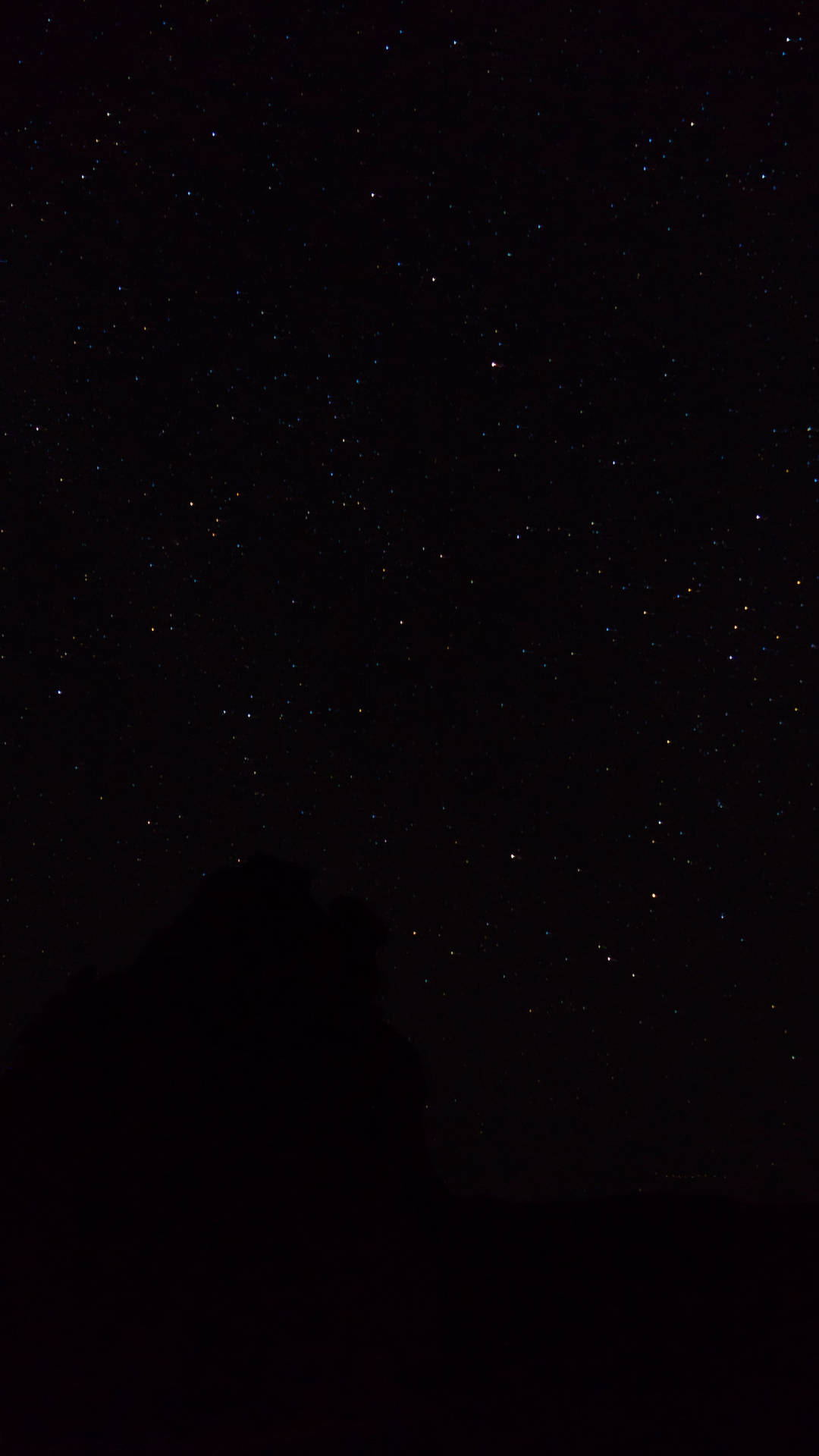 黑暗的山脈輪廓在繁星點點的夜空下。