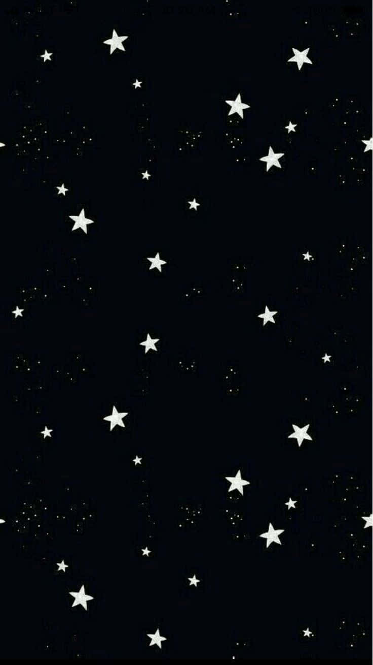 黑色背景上帶有白色星星和發光點的星空。