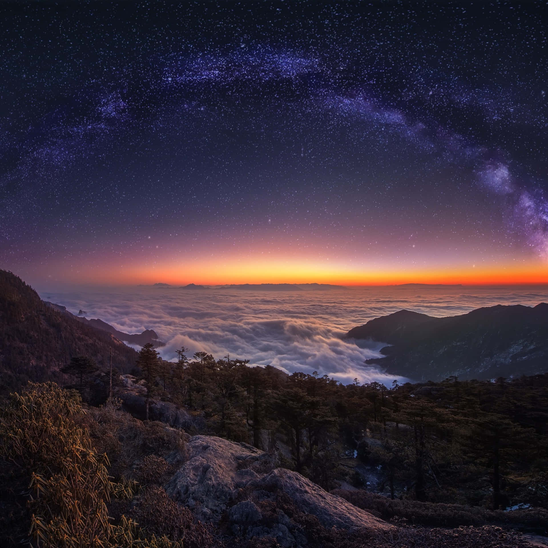 夜晚的山脊，下方有雲，上方有銀河