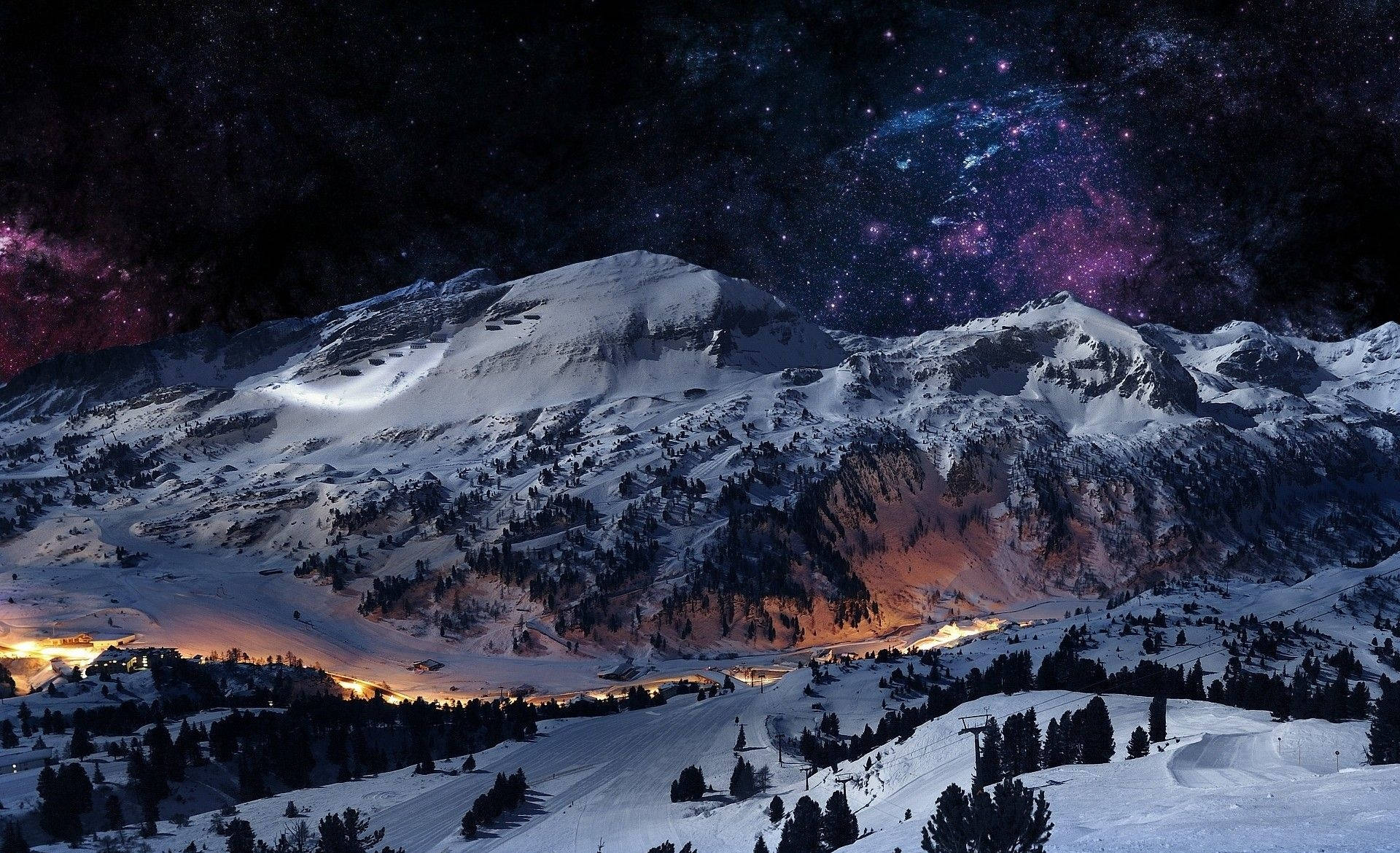 積雪的山脈在星空下，伴隨著閃耀的山谷燈光和紫色星雲。