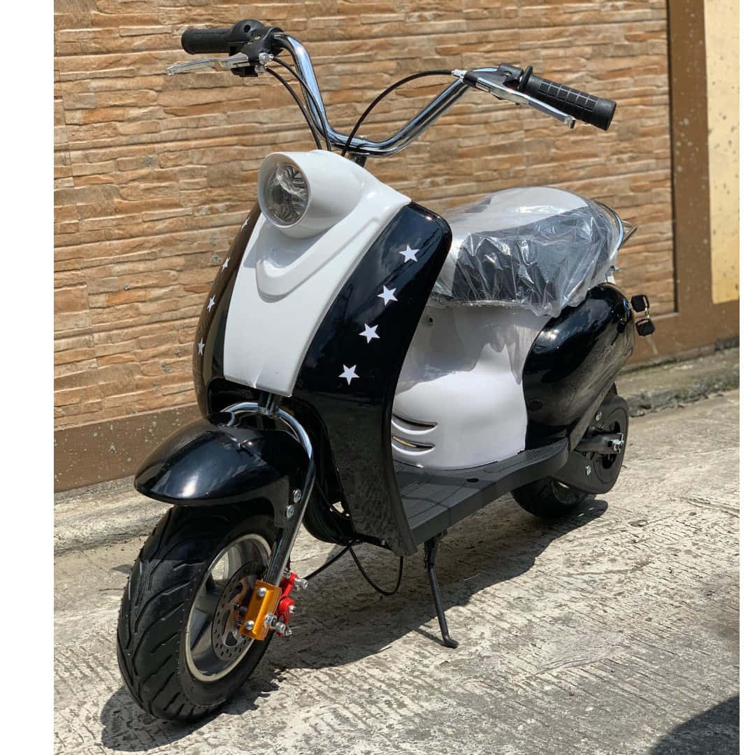 帶有星星貼紙的黑白電動滑板車停在行人路上。