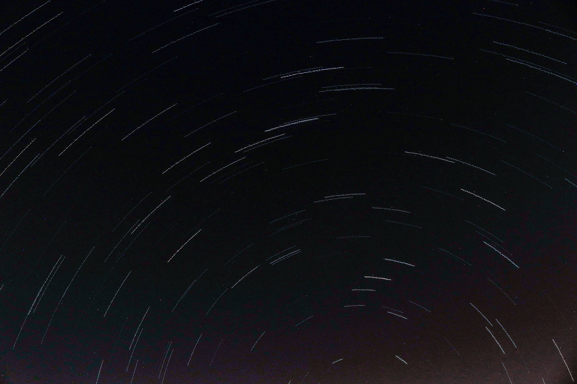 星軌在長時間曝光的照片中彎曲穿過黑暗的夜空。