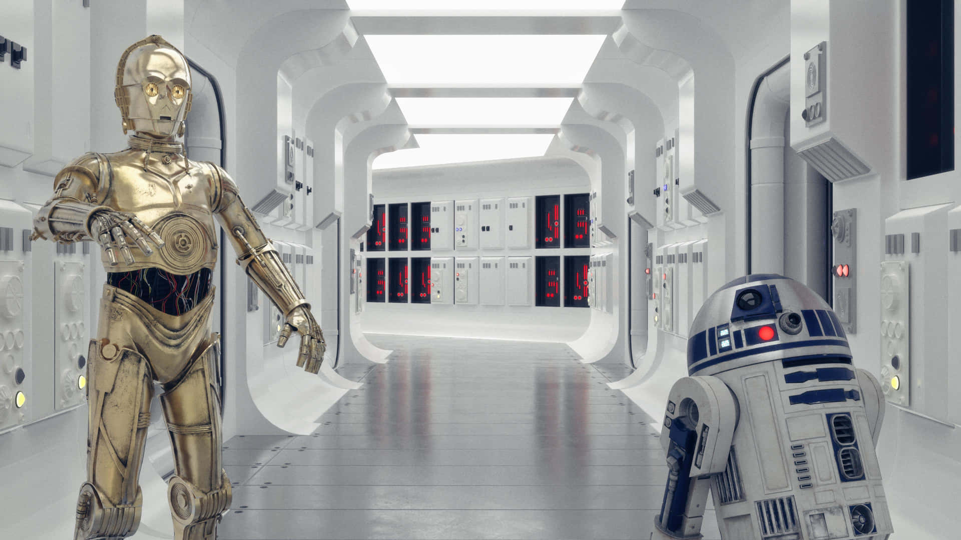 C-3PO 和 R2-D2 在一個帶有紅色發光面板的太空船走廊中。
