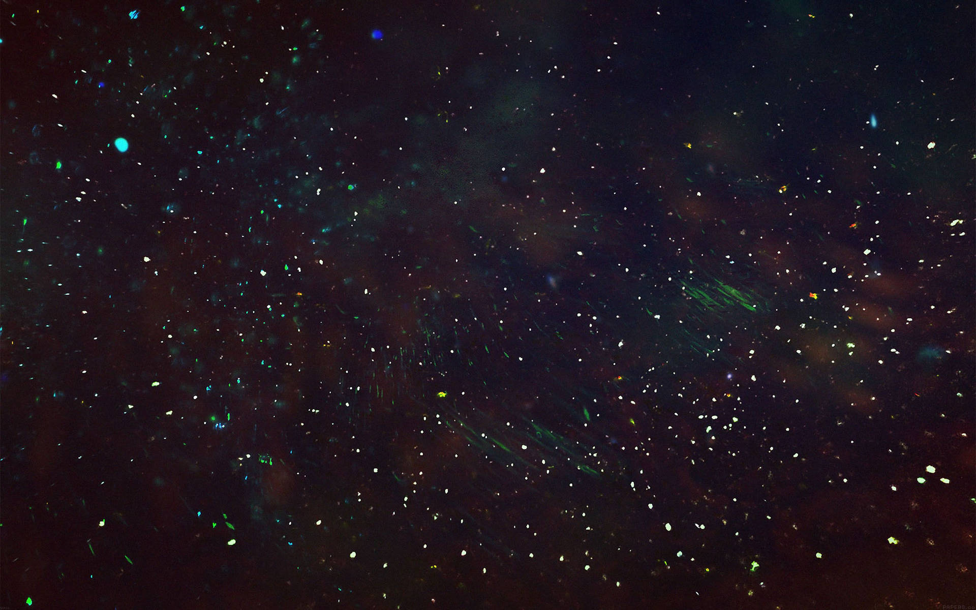 發光的綠色和藍色粒子漂浮在黑暗的宇宙虛空中。
