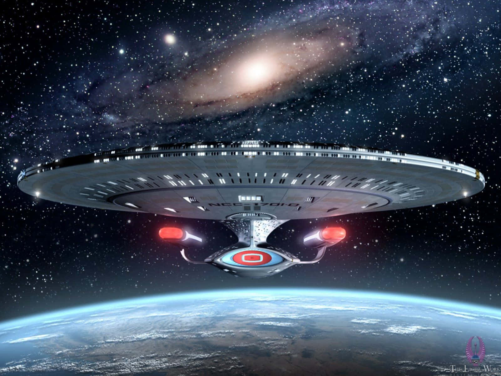 星艦 NCC 1701D 環繞著一顆藍色行星運行，背景是螺旋星系。