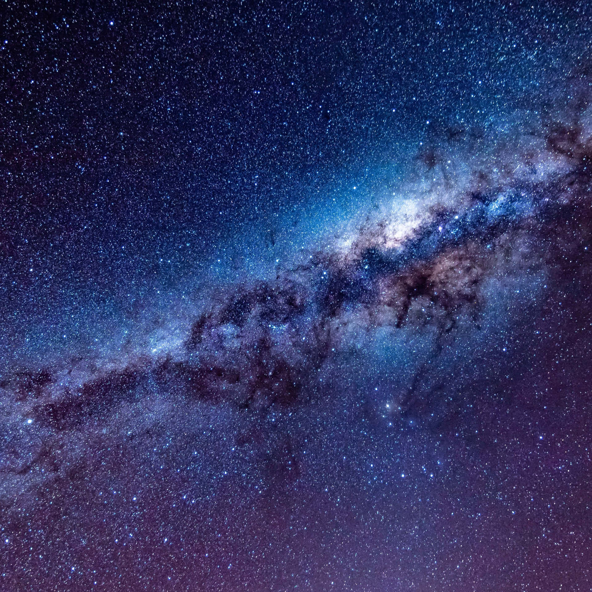 銀河系在漆黑的夜空中閃爍著藍色和紫色的星星。