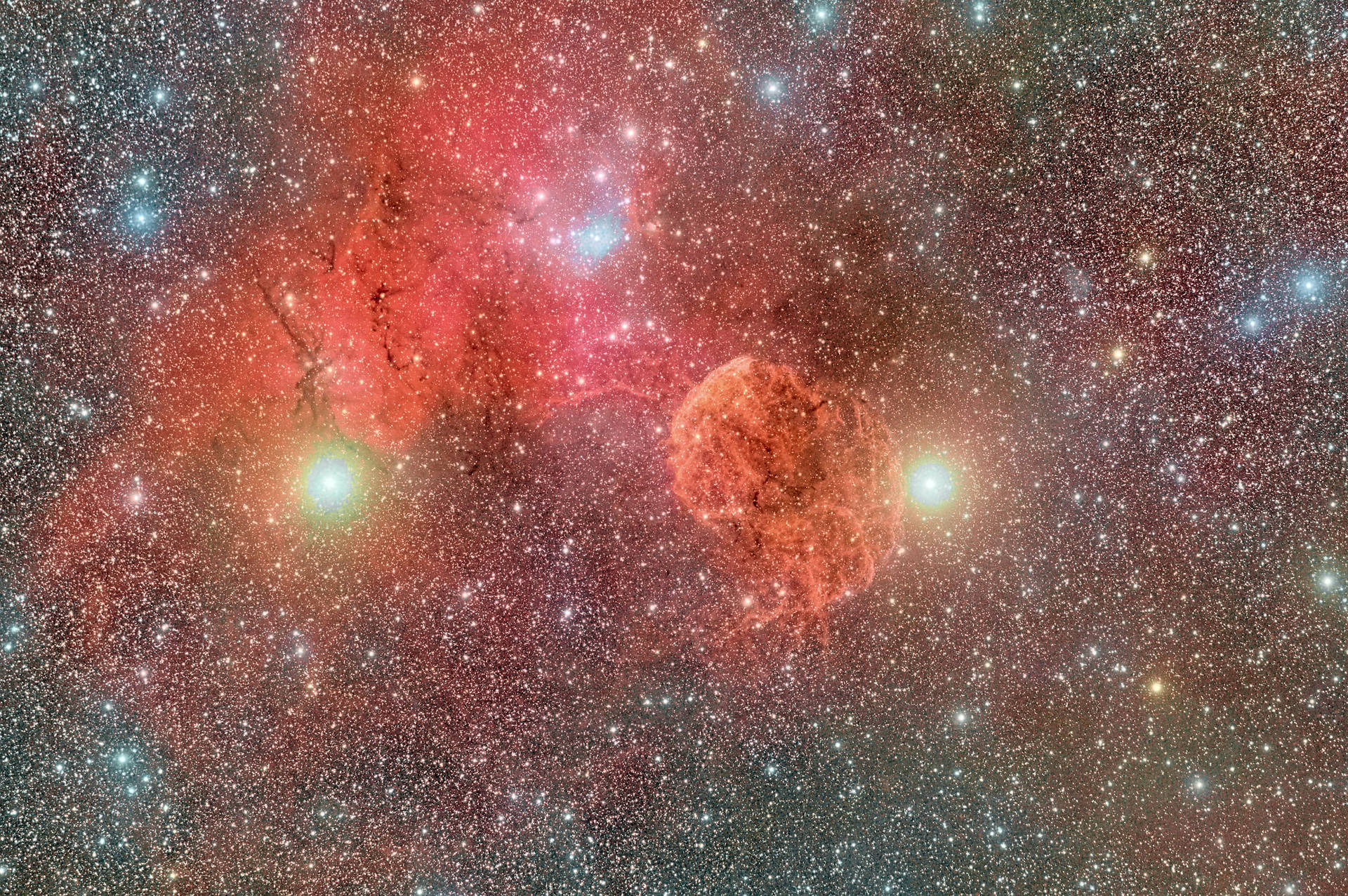 一個發光的紅色和橙色星雲，充滿了恆星和明亮的恆星核心，在深空中。