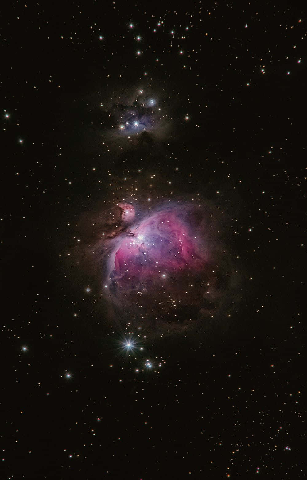 星雲深空圖像 壁紙 — 一片充滿活力的粉紅色和紫色星雲在深空的星群中發光。