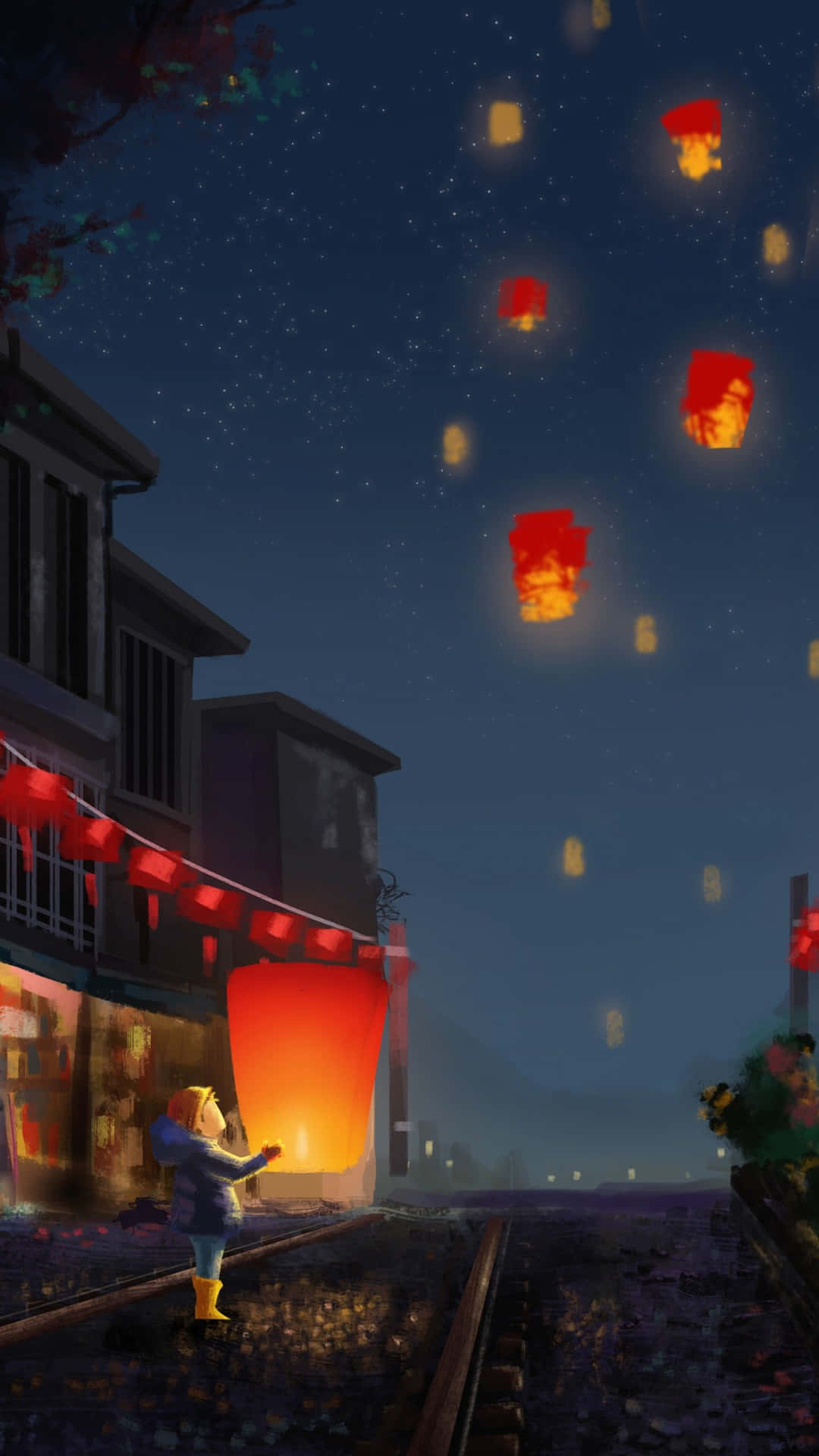 小孩在星空下的寧靜街道上放飛發光的紅色燈籠。