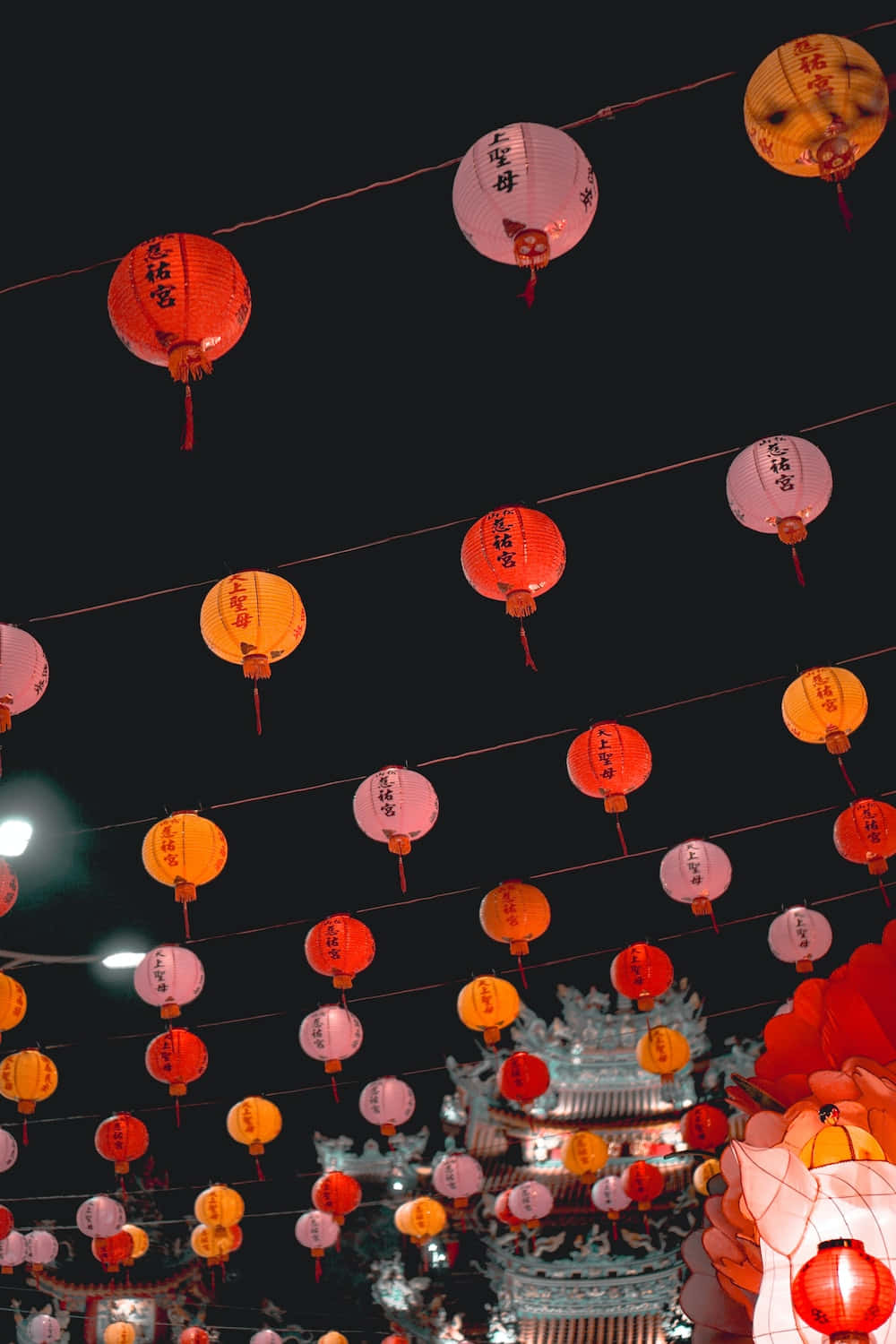 夜晚，寺廟上方懸掛著一排排彩色燈籠。