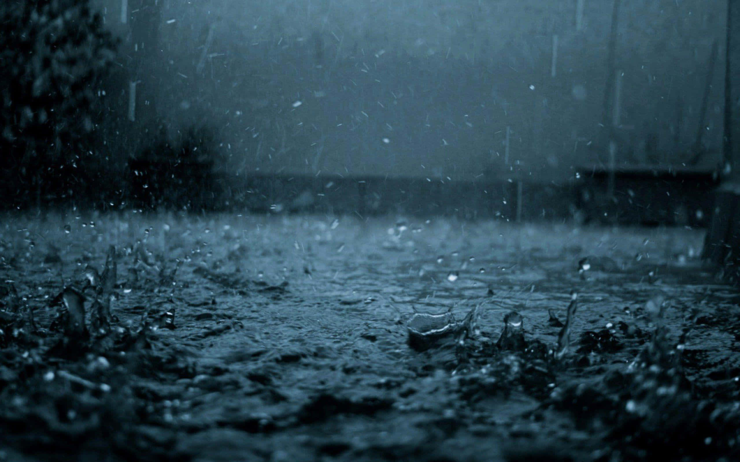 春雨清新自然 壁紙 — 沉重的雨點在陰沉多雲的天空下，戲劇性地濺落在黑暗潮濕的路面上。