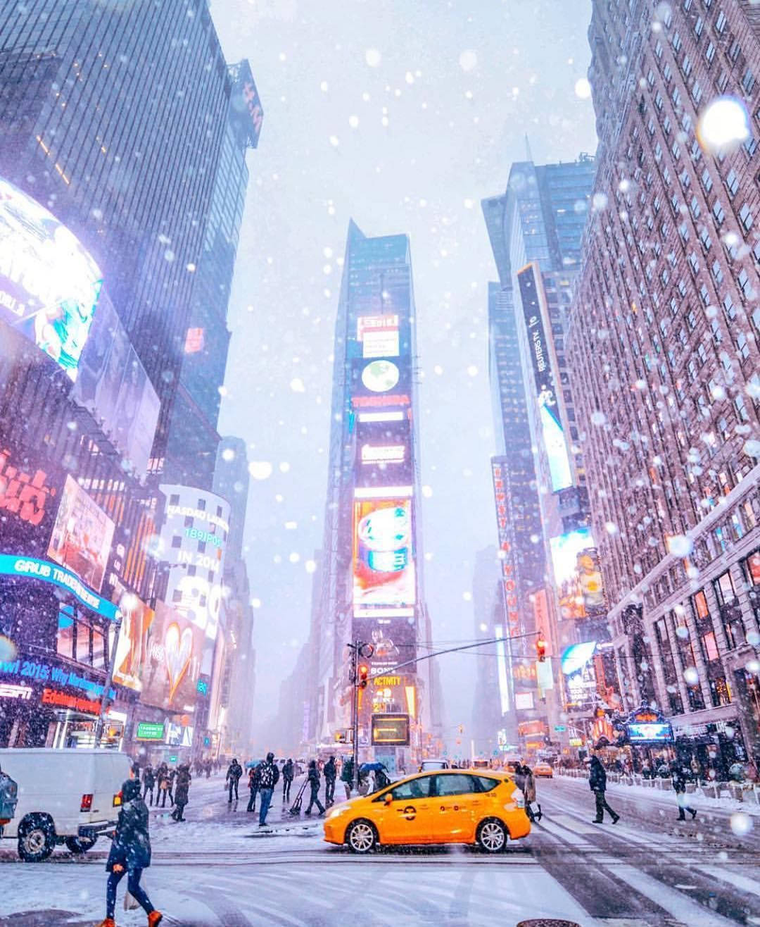 時代廣場下雪，有明亮的廣告牌和一輛黃色的士。