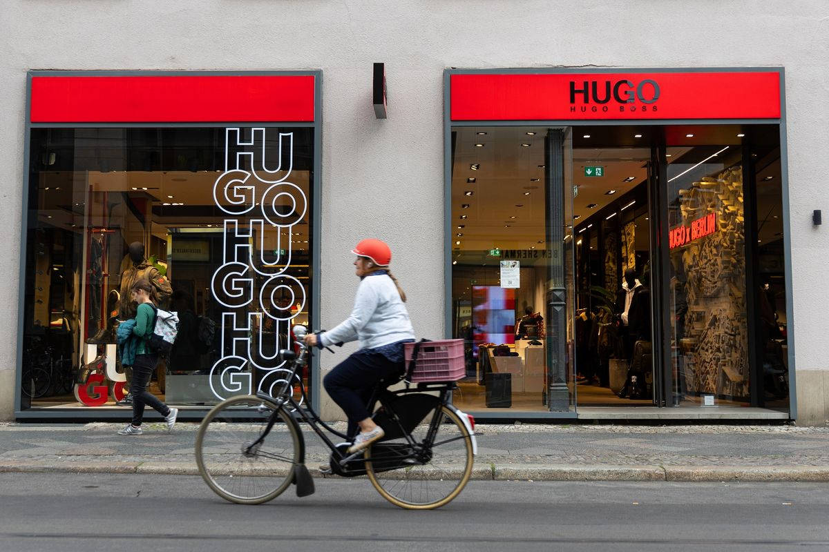 戴紅色頭盔的單車手在街上騎過Hugo Boss店舖前。
