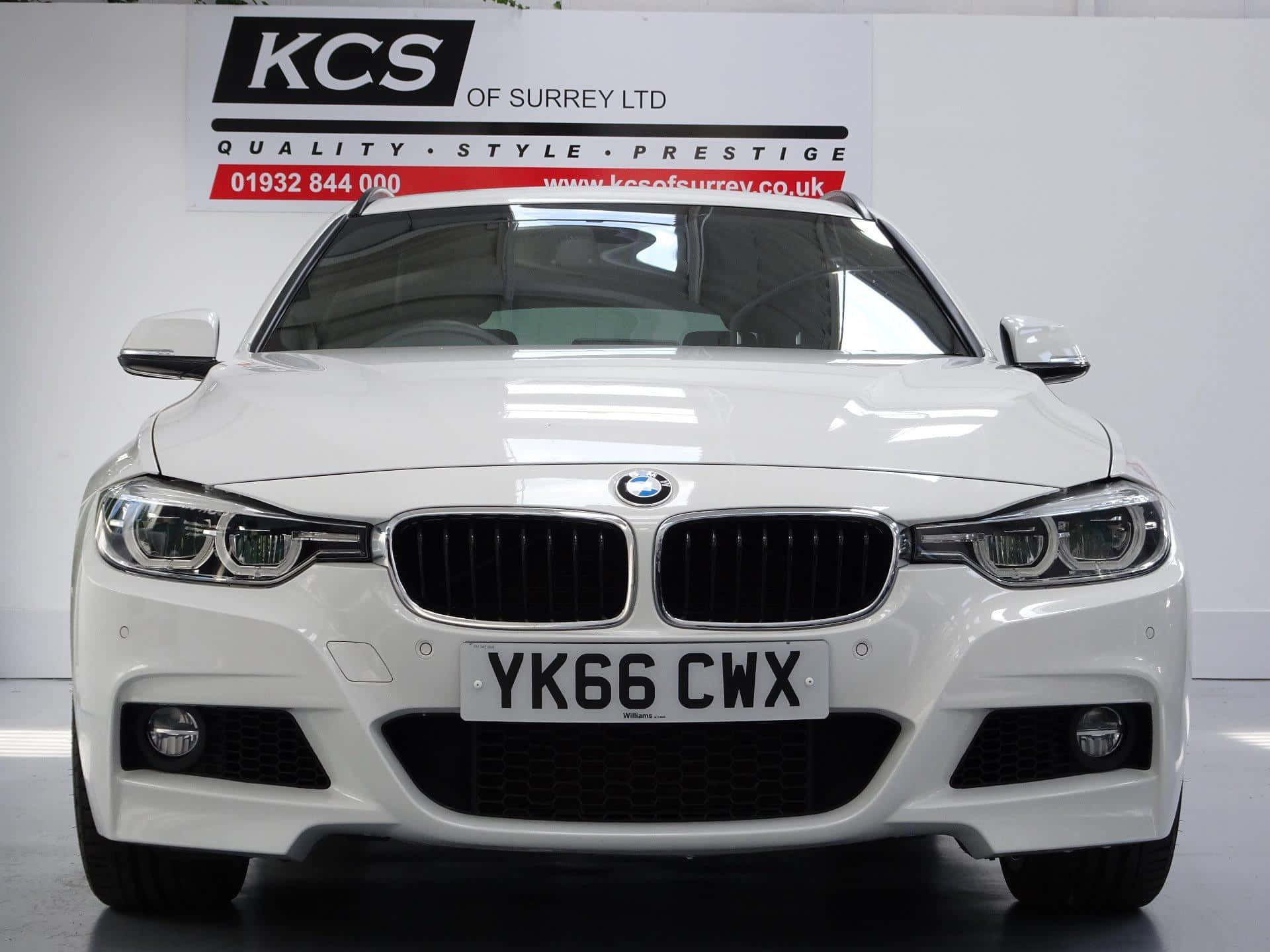 時尚BMW M系列車款夜景背景 壁紙 — 一輛純白色的BMW 3系房車在乾淨的攝影棚中展示，背景有經銷商標誌。