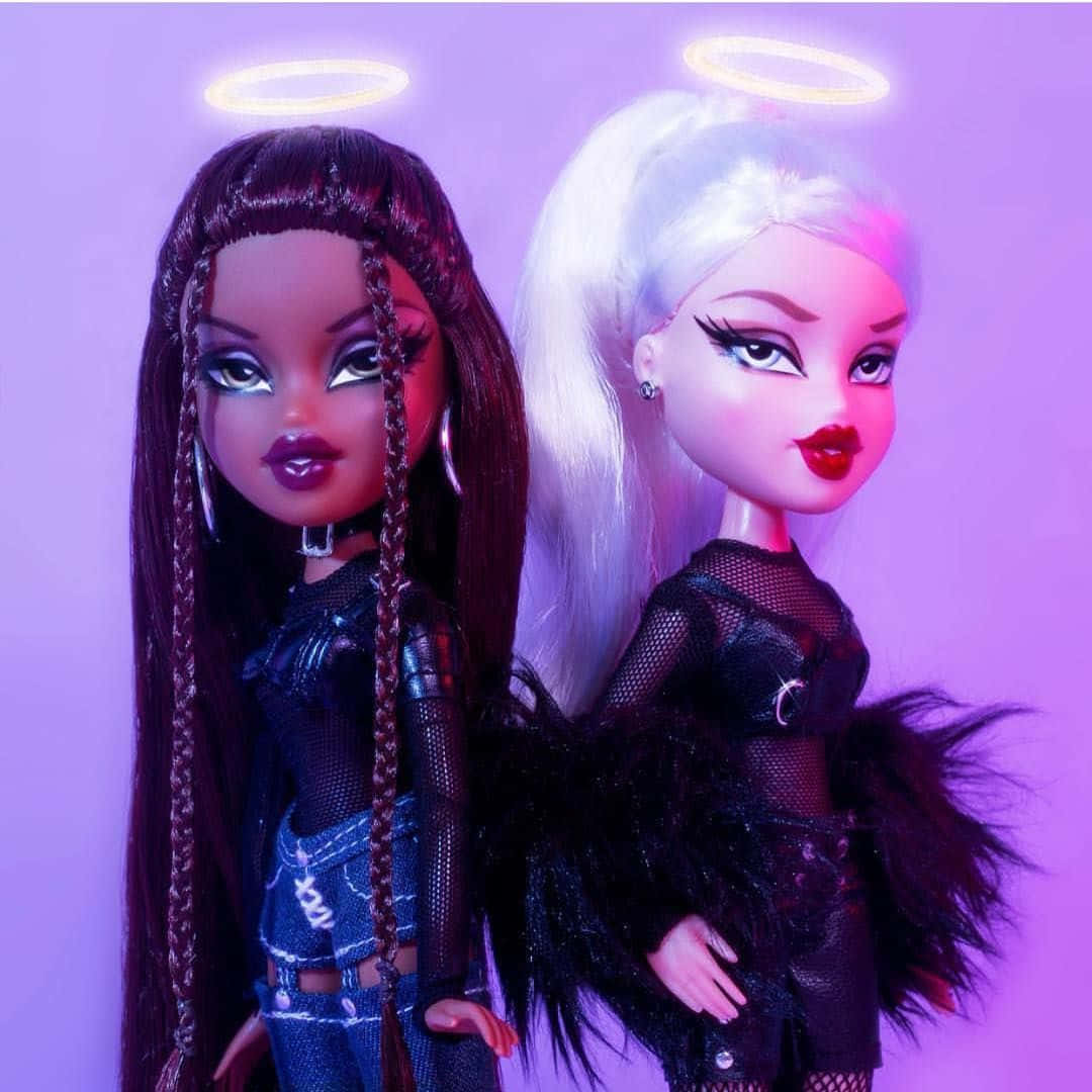 時尚Bratz娃娃插畫 壁紙 — 兩個帶有發光光環的 Bratz 公仔，在紫色背景前穿著前衛的黑色服裝。
