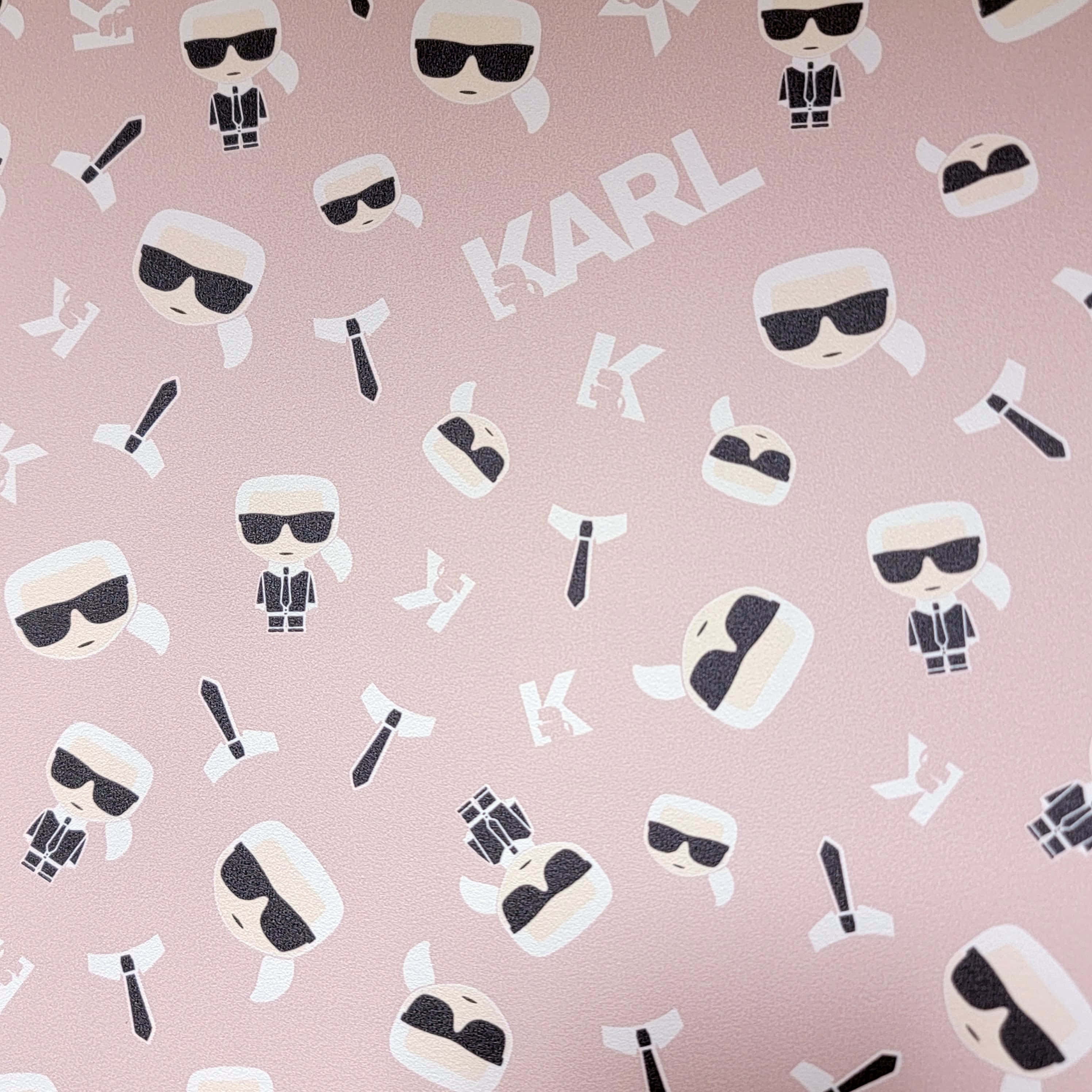 時尚傳奇——卡爾·拉格斐 壁紙 — 粉紅色紋理牆紙，帶有重複的卡通Karl Lagerfeld圖標和白色字母。