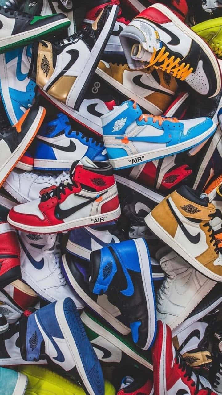 時尚前衛的 Off White 鞋款 壁紙 — 一堆色彩繽紛的Air Jordan運動鞋，設計大膽、顏色多樣，充滿活力且雜亂無章。