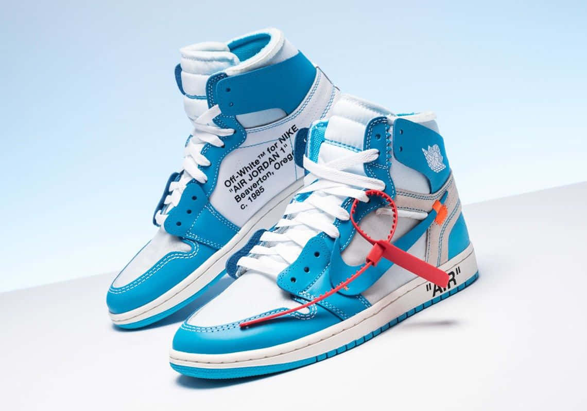 時尚前衛的 Off White 鞋款，為潮流人士量身打造 壁紙 — 一對藍白色高筒運動鞋，帶有紅色標籤細節，置於柔和漸變背景上。