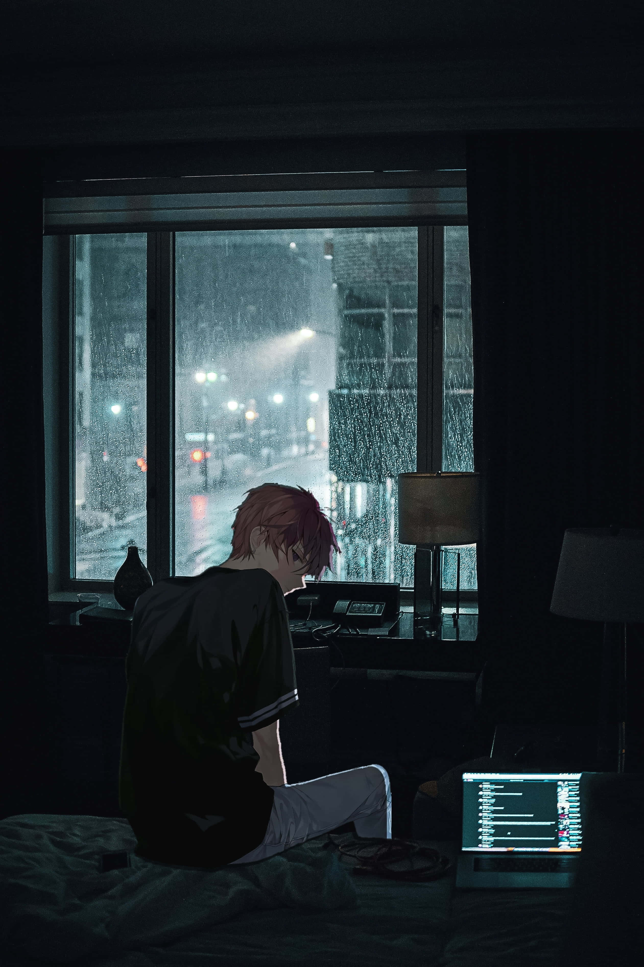 時尚動畫男孩在電腦前工作 壁紙 — 一個紅髮動畫男孩坐在黑暗房間的床上，凝視著被雨水打濕的窗外，看著被遠處路燈照亮的城市街道。