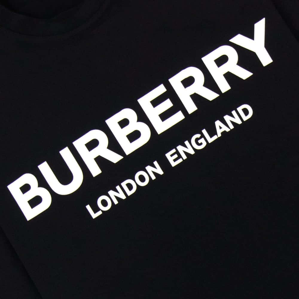 時尚品味 壁紙 — 黑色布料衣物上粗體白色 Burberry London England 文字的近距離特寫。