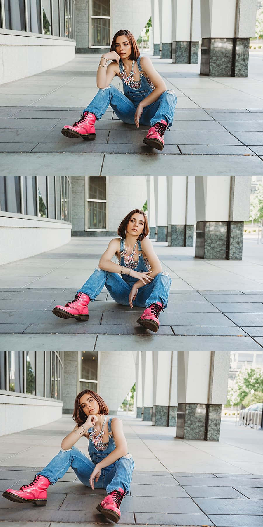 時尚坐姿女性照片 壁紙 — 一位年輕女性身穿牛仔工人褲和亮粉紅色靴子，在日光下的現代瓷磚廣場上自信地擺姿勢。