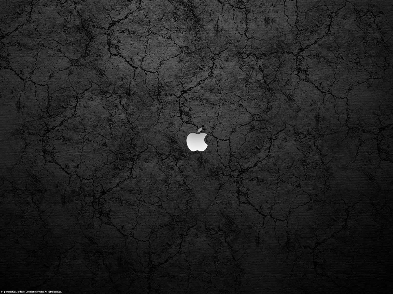 銀色Apple標誌在破裂的黑色混凝土背景上。