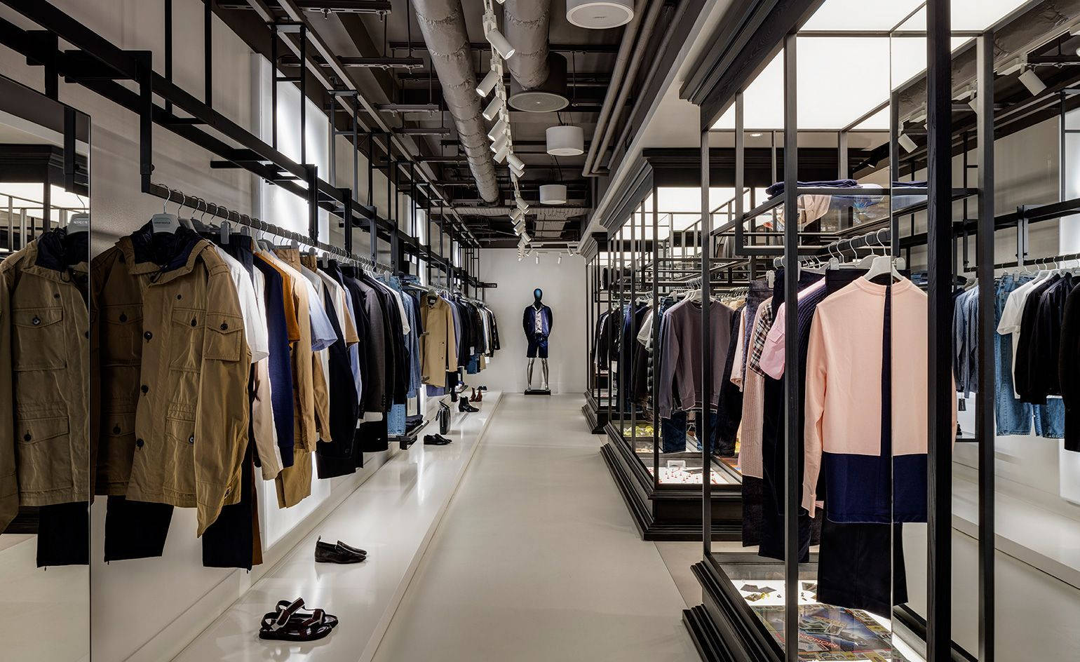 現代服裝店，配有黑色貨架和白色牆壁，中央有一個人體模型。