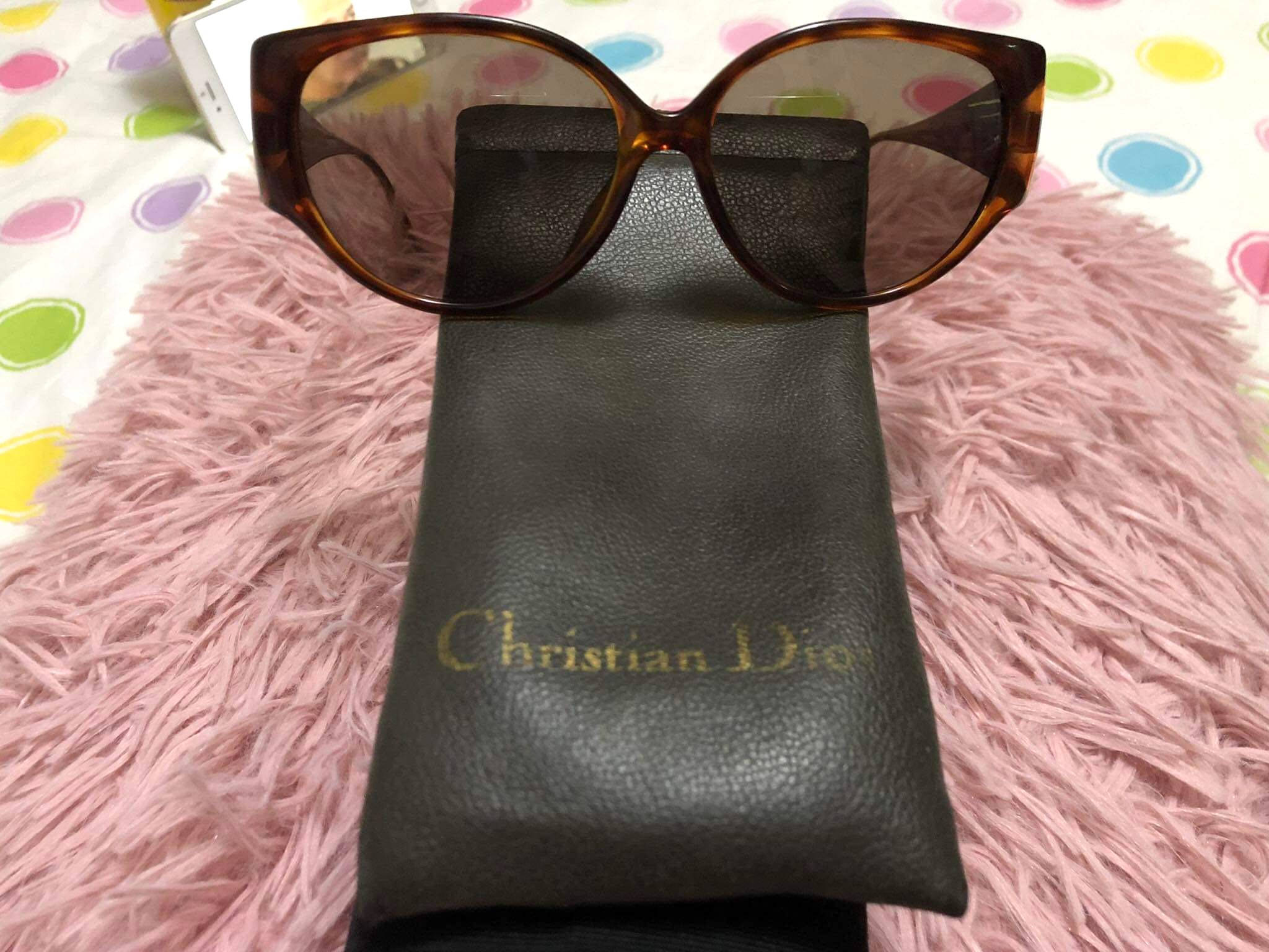 時尚復古 基督山迪奧太陽眼鏡 壁紙 — 玳瑁色太陽眼鏡放在黑色 Christian Dior 眼鏡盒上，置於有彩色圓點的粉紅色毛絨地毯上。