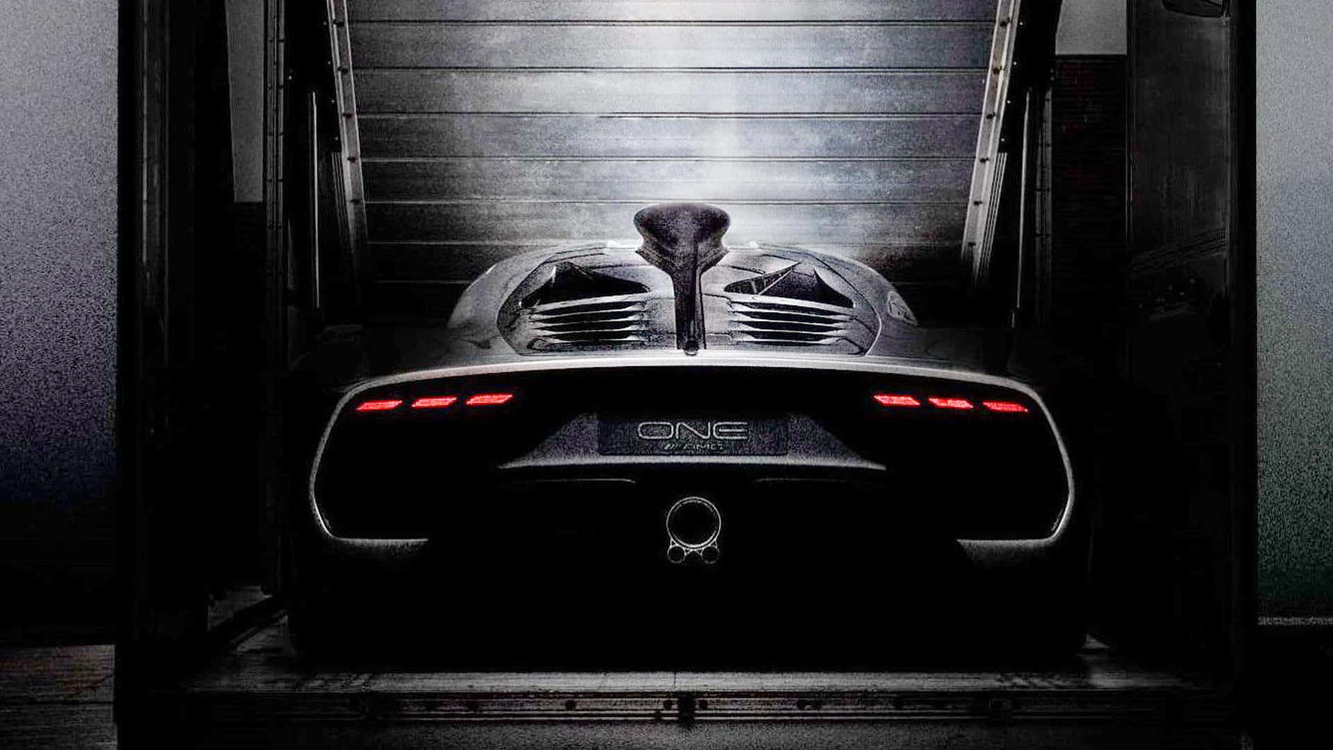 黑色Koenigsegg One-1超級跑車，在黑暗的工業車庫中帶有紅色尾燈。
