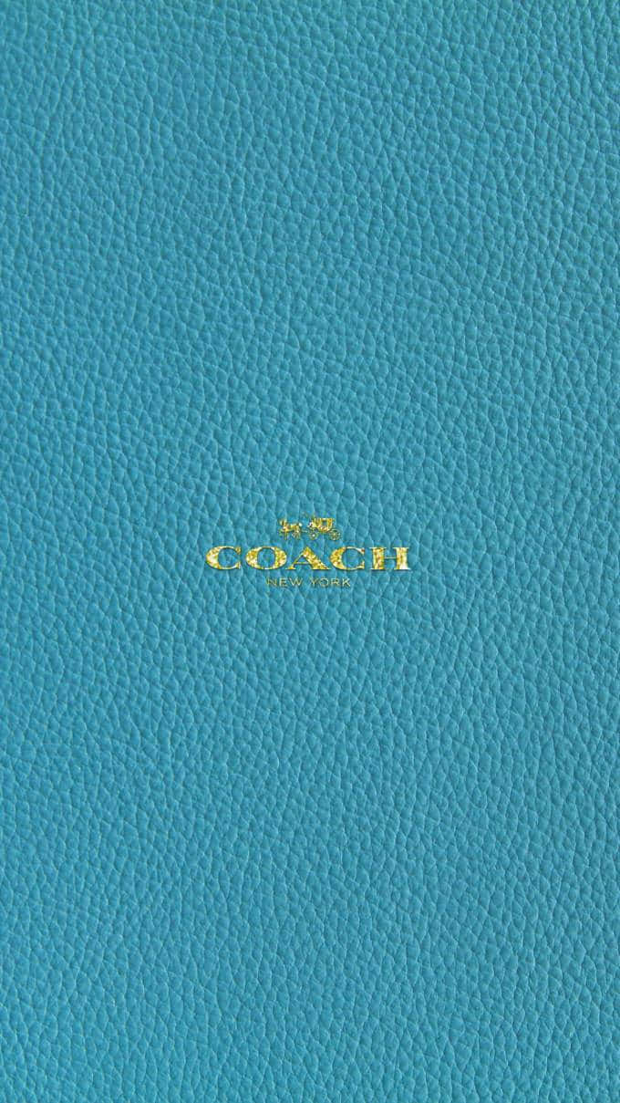 土耳其藍色皮革Coach錢包，帶金色標誌。