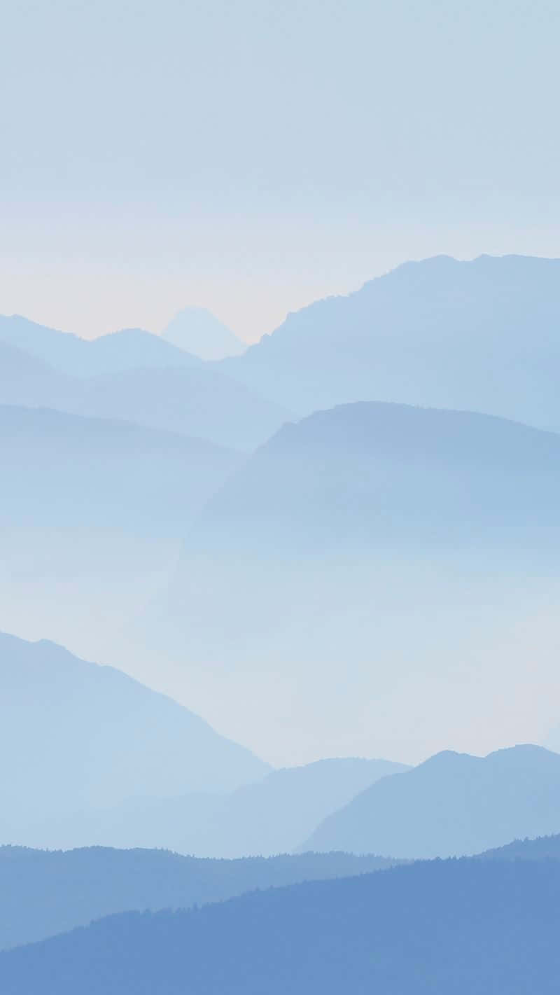 柔和的藍色山層在黎明時分消失在霧中。