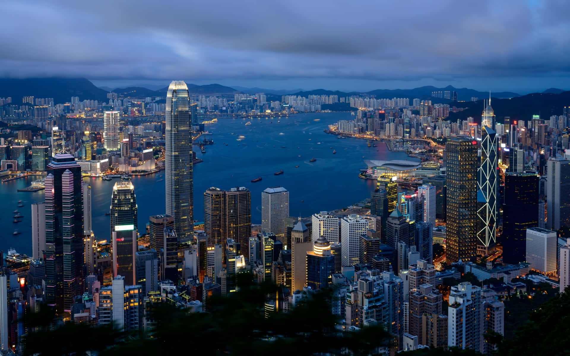 黃昏時分的香港城市景觀，燈火通明的摩天大樓和港口。