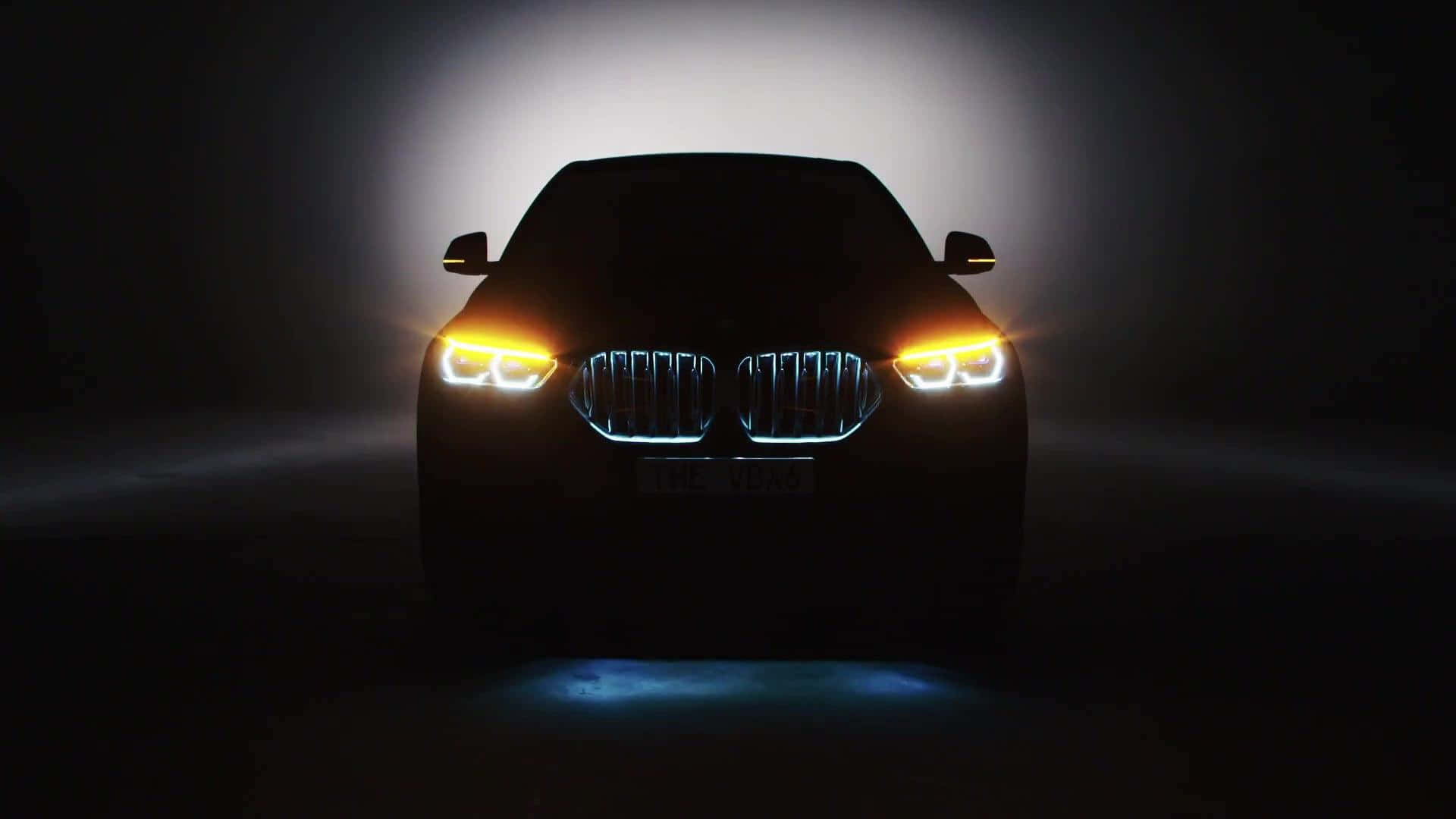 Vantablack 桌布 壁紙 — 時尚的BMW SUV輪廓在黑暗迷濛的背景中閃爍著鮮豔的車頭燈和發光的鬼面罩。