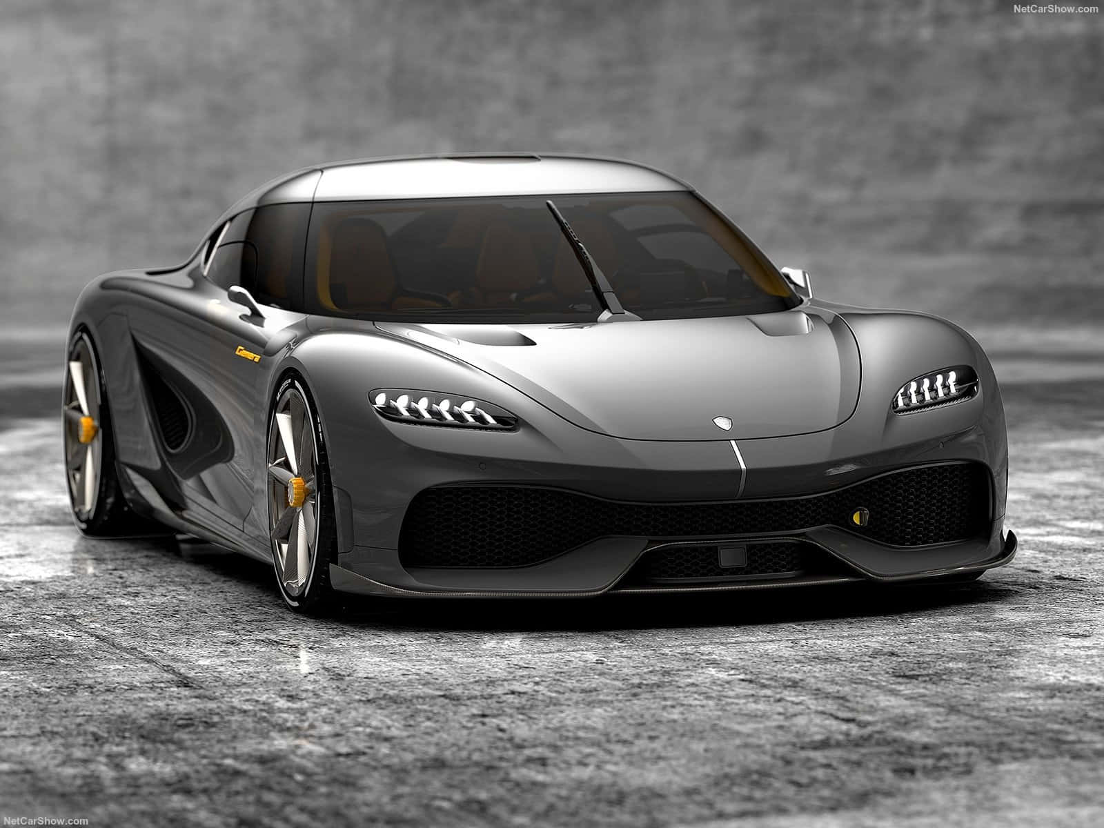 銀色 Koenigsegg Jesko 超跑帶有黃色點綴，在混凝土地板上。