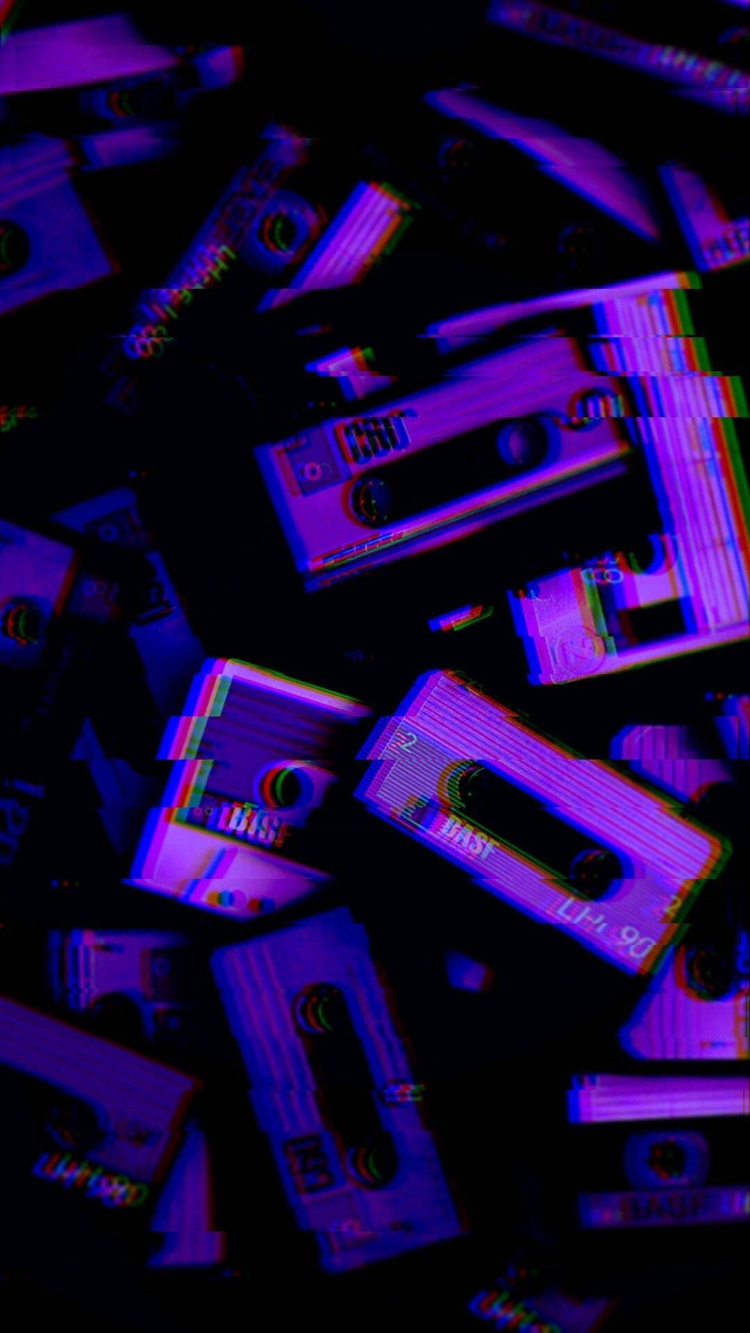 時尚紫色音樂磁帶 壁紙 — 帶有數位失真效果的紫色和藍色卡式錄音帶在黑暗中漂浮。