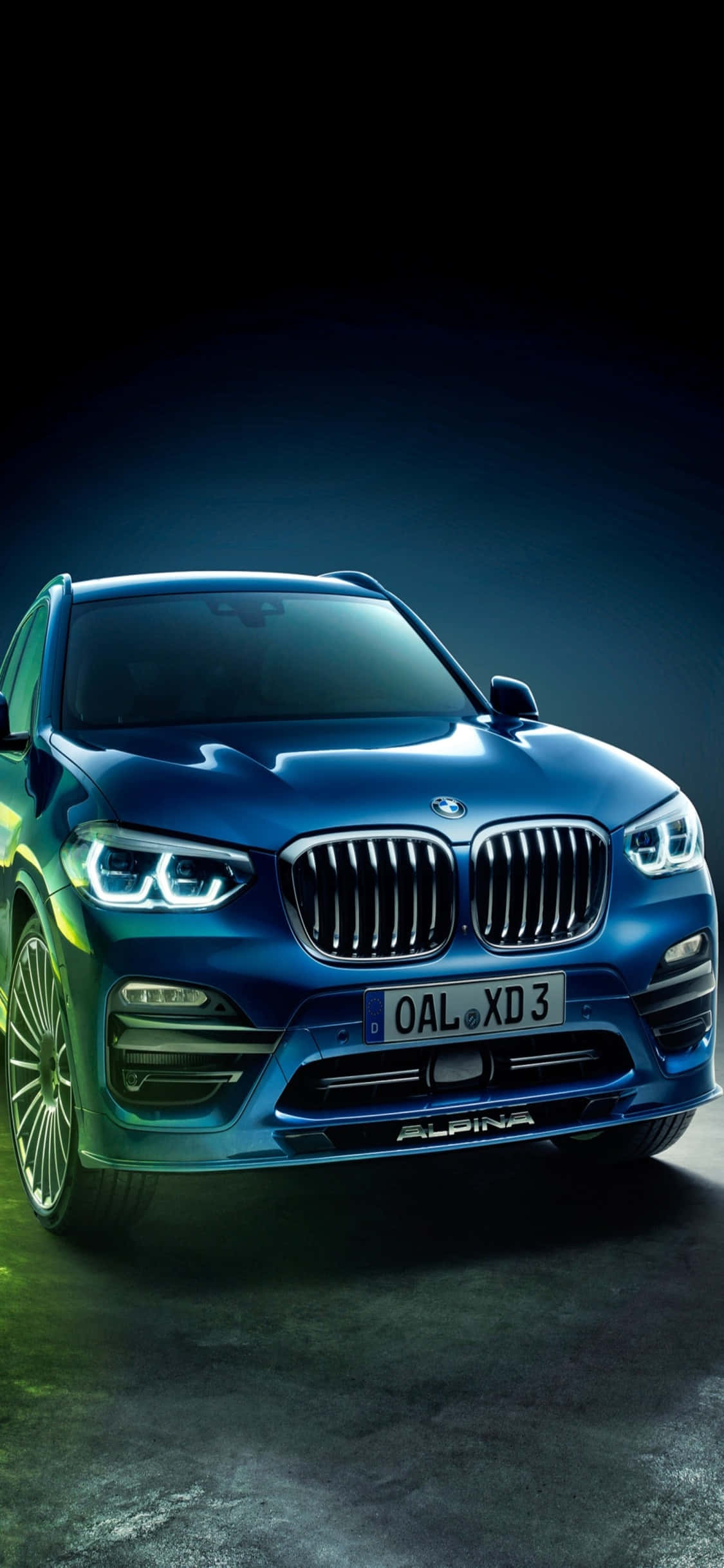 時尚組合：iPhone X與BMW 壁紙 — 一輛時尚的藍色Alpina BMW SUV在戲劇性的工作室燈光下，在黑暗的背景中閃耀。