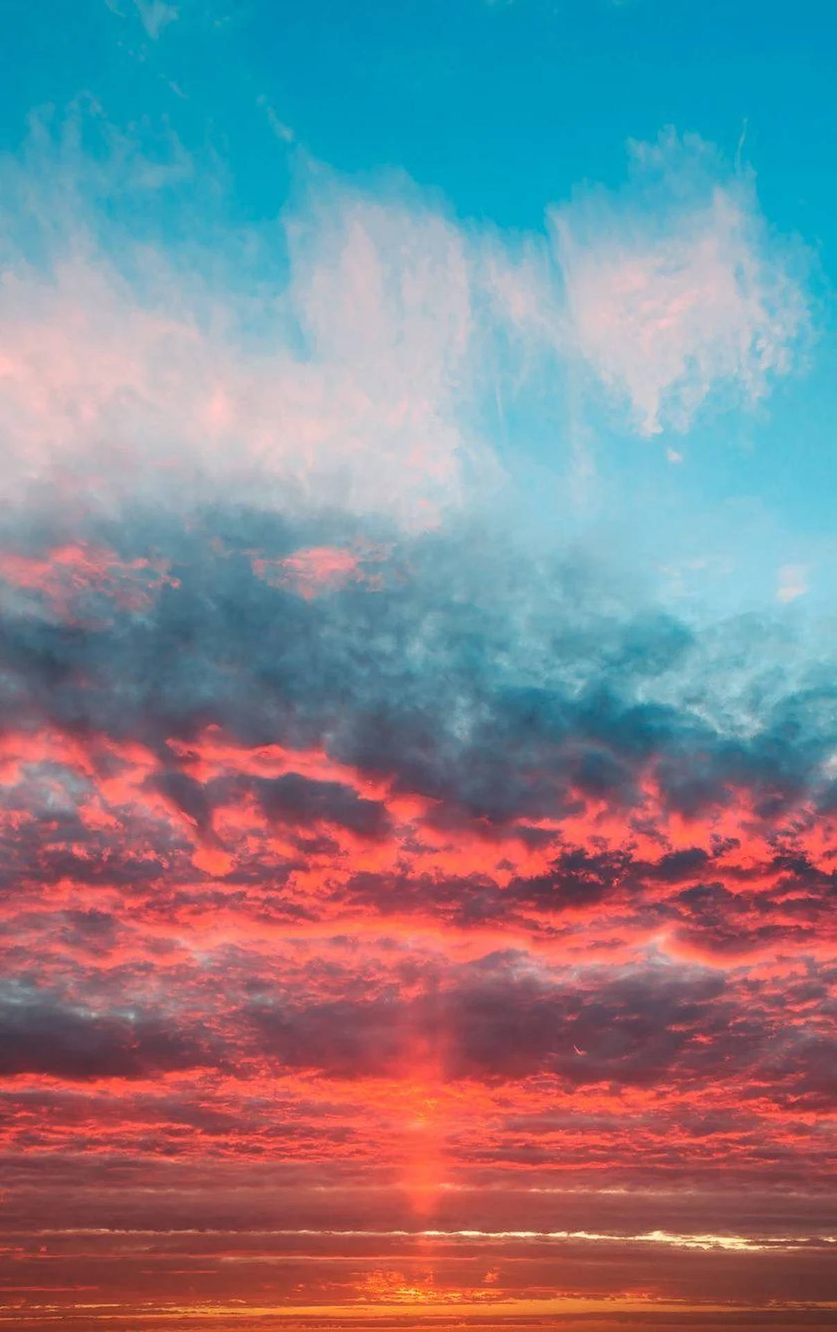 日落時分，平靜的地平線上空，鮮豔的紅色和橙色雲彩。