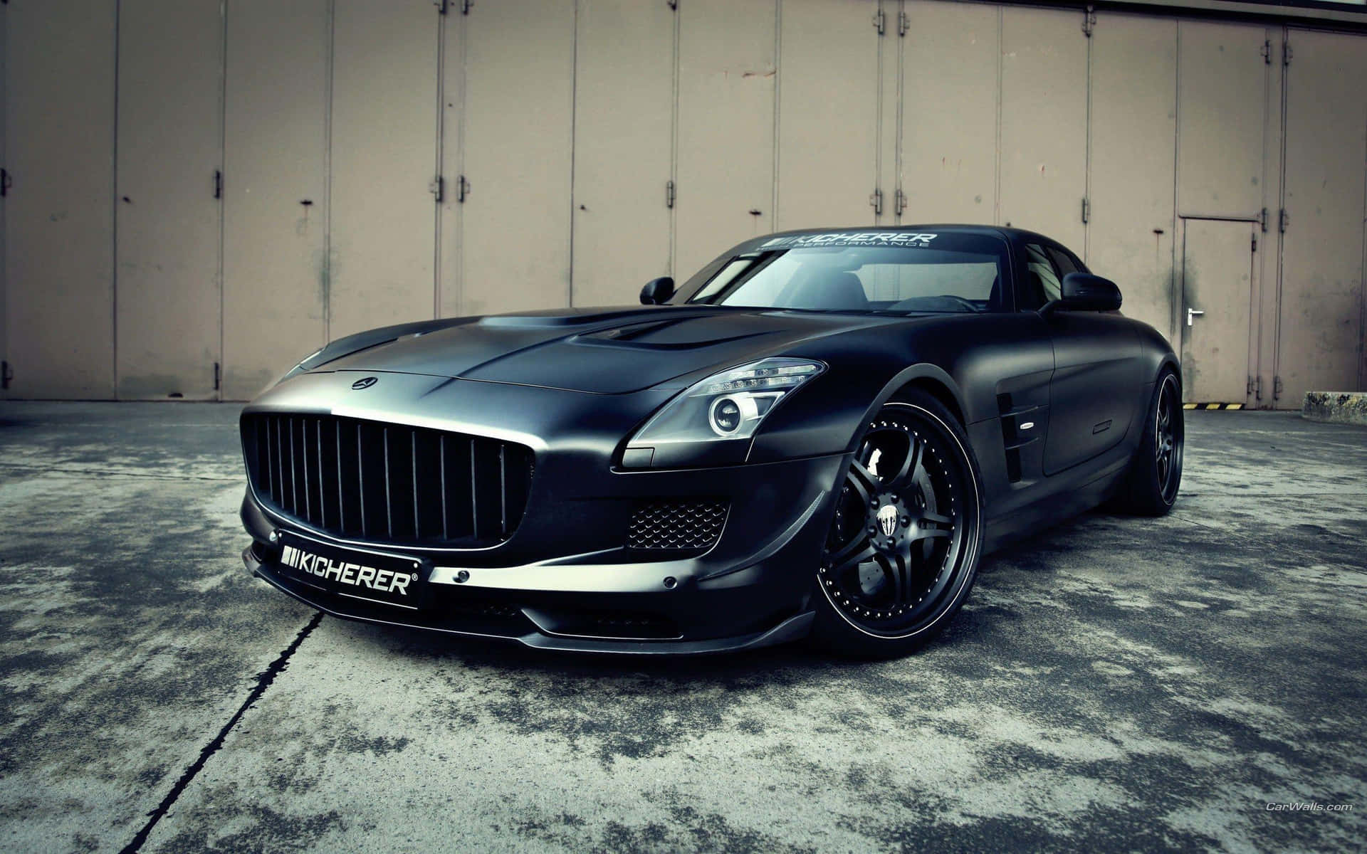 工業車庫場景中嘅啞黑色Mansory SLS AMG跑車。