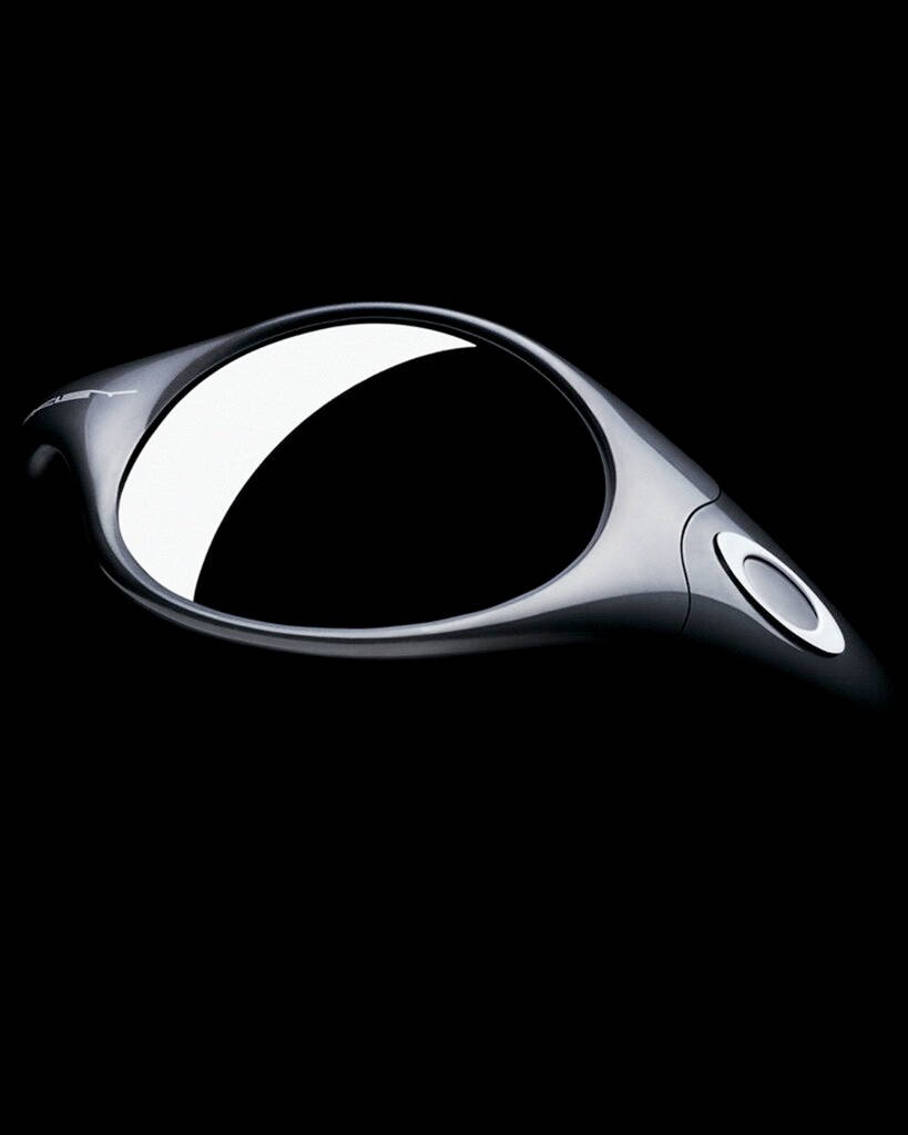時尚黑色 Oakley 男士太陽眼鏡 壁紙 — 純黑色背景上，一個時尚的銀色未來裝置，帶有發光的白色新月形和圓形按鈕。